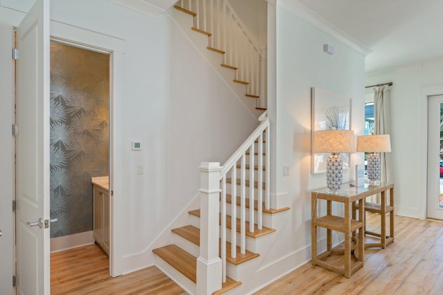 staircase featuring hardwood / wood-style flooring and ornamental molding