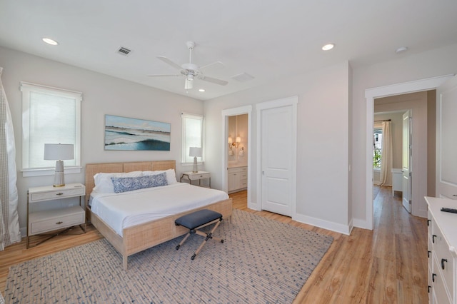 bedroom featuring light wood-type flooring, ensuite bathroom, and ceiling fan