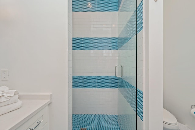 bathroom featuring vanity, toilet, and a shower with door