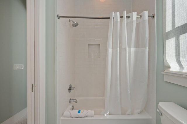 bathroom featuring toilet and shower / tub combo with curtain