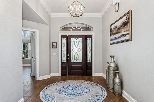 foyer entrance with crown molding, dark wood-type flooring, and a chandelier