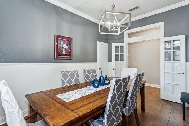 dining area featuring dark wood-type flooring, ornamental molding, and a chandelier