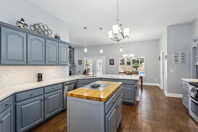 kitchen with pendant lighting, wooden counters, a kitchen island, kitchen peninsula, and a chandelier