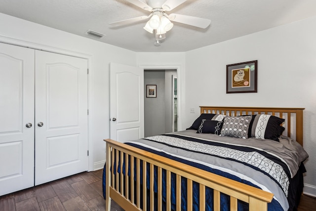 bedroom with dark wood-type flooring, a closet, and ceiling fan