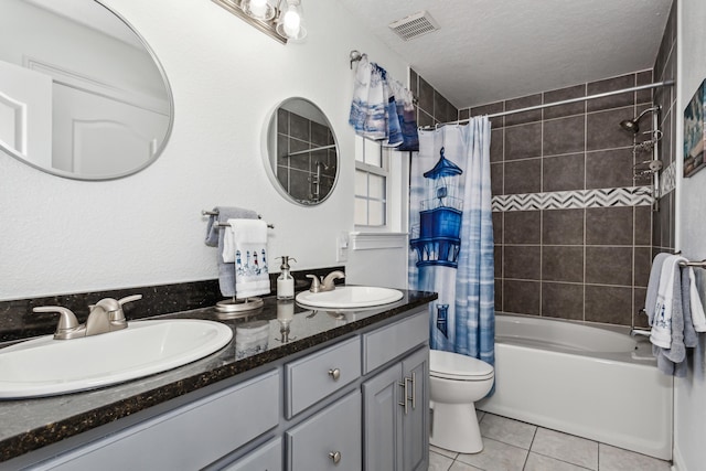 full bathroom with a textured ceiling, vanity, toilet, shower / bathtub combination with curtain, and tile patterned floors