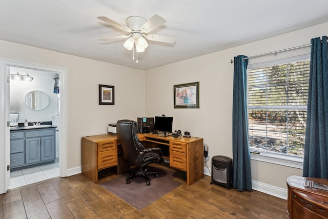 office area with ceiling fan, sink, and a textured ceiling