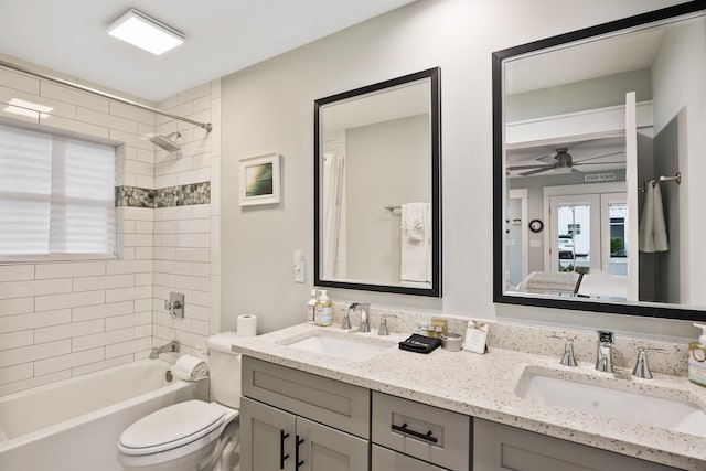 full bathroom featuring tiled shower / bath, vanity, toilet, and ceiling fan