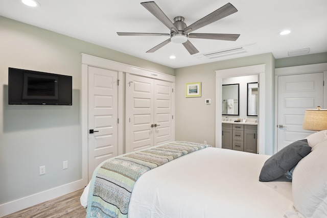 bedroom featuring light hardwood / wood-style floors, ensuite bath, and ceiling fan