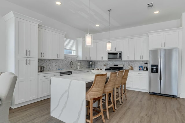 kitchen featuring a center island, white cabinetry, and appliances with stainless steel finishes