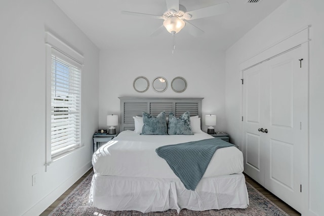 bedroom featuring ceiling fan, dark hardwood / wood-style flooring, and a closet