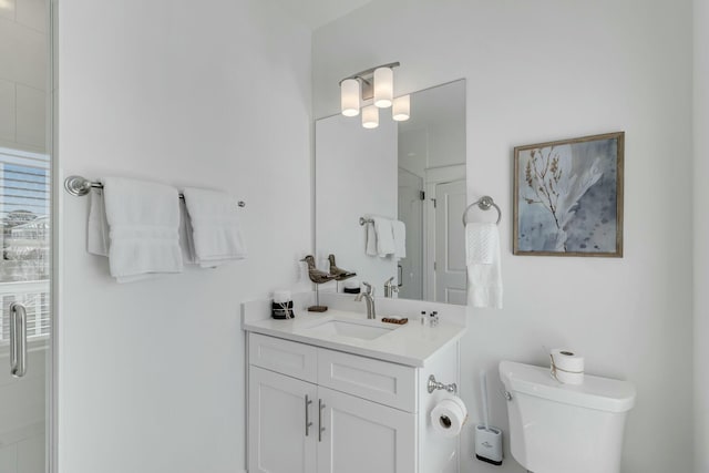 bathroom featuring vanity, toilet, and a shower with shower door