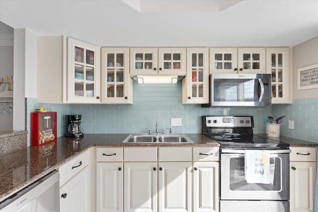 kitchen with decorative backsplash, stainless steel appliances, white cabinetry, and sink