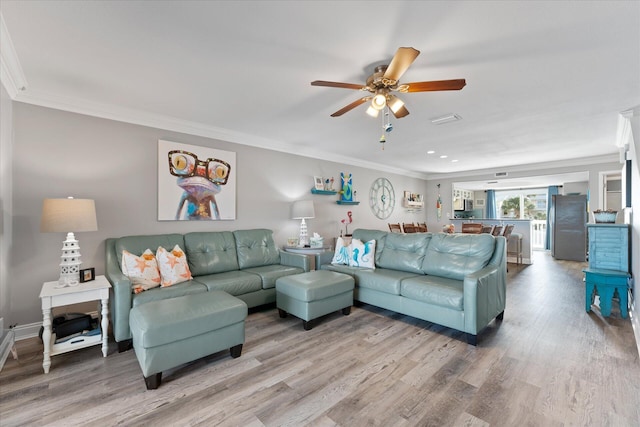 living room featuring ceiling fan, wood-type flooring, and ornamental molding