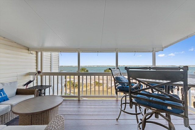 sunroom featuring a water view