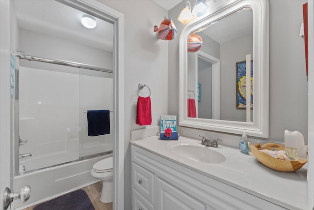 full bathroom featuring vanity, hardwood / wood-style flooring, toilet, and bath / shower combo with glass door