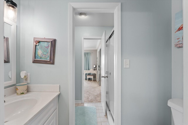 bathroom with tile patterned flooring, crown molding, toilet, vanity, and a shower with shower door