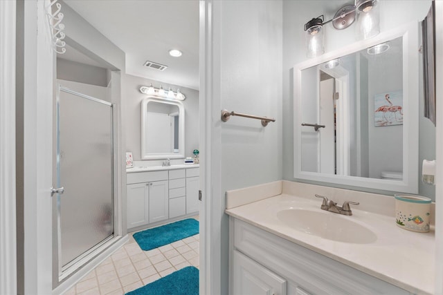 bathroom with tile patterned flooring, vanity, a shower with shower door, and toilet