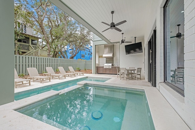 view of swimming pool with a ceiling fan, outdoor dining area, an outdoor kitchen, a patio area, and fence private yard
