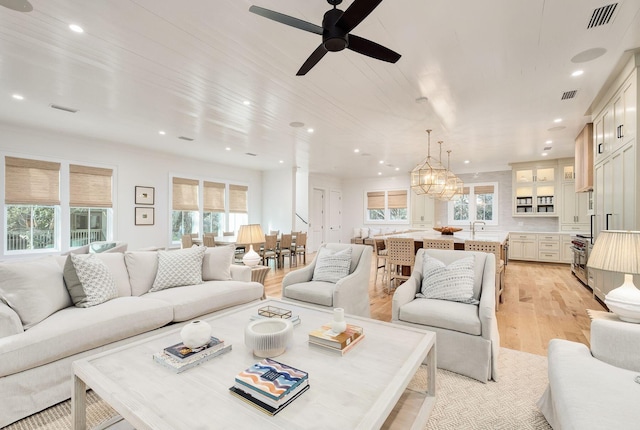 living room with ceiling fan, recessed lighting, visible vents, and light wood-style floors