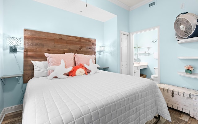 bedroom featuring dark wood-type flooring, ensuite bath, and crown molding