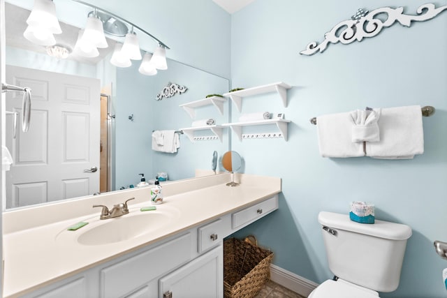 bathroom featuring vanity, a shower with shower door, and toilet