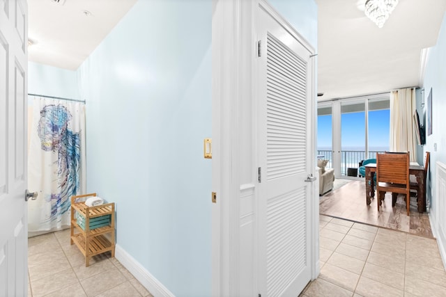 hall featuring a water view and light tile patterned flooring