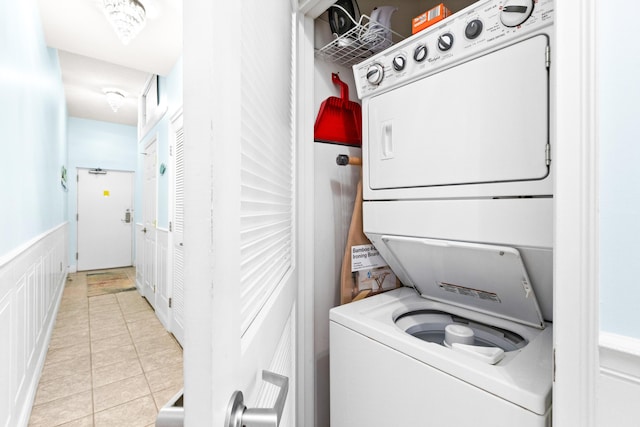 laundry room with light tile patterned flooring and stacked washing maching and dryer