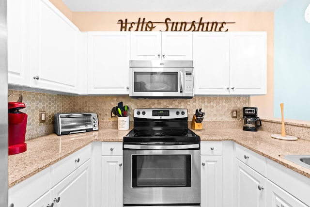 kitchen with white cabinets, decorative backsplash, and stainless steel appliances