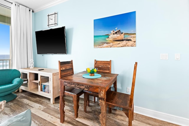 dining room with hardwood / wood-style flooring and crown molding