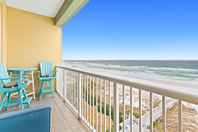 balcony featuring a water view and a view of the beach