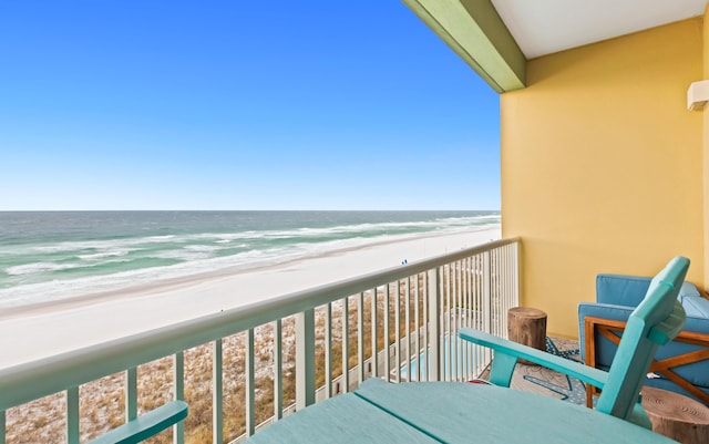 balcony with a water view and a view of the beach