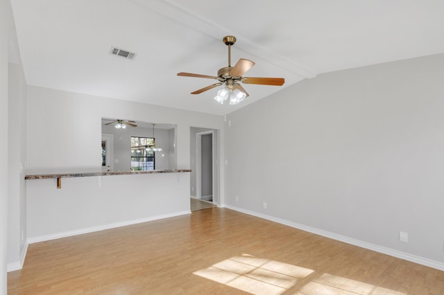 unfurnished living room featuring vaulted ceiling with beams, ceiling fan, and light hardwood / wood-style floors