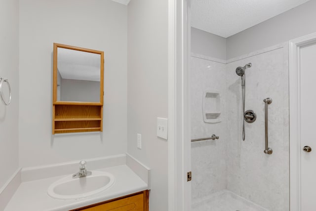 bathroom featuring vanity, a shower, and a textured ceiling