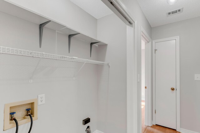 washroom with washer hookup and hardwood / wood-style flooring