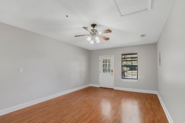 unfurnished room with ceiling fan, hardwood / wood-style floors, and a textured ceiling