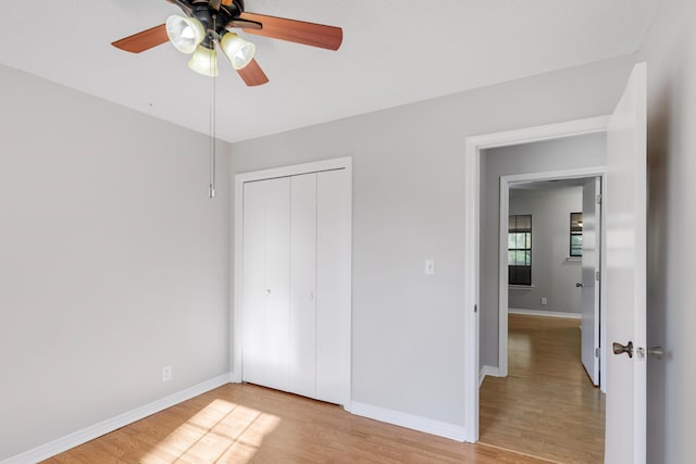 unfurnished bedroom featuring a closet, light hardwood / wood-style flooring, and ceiling fan