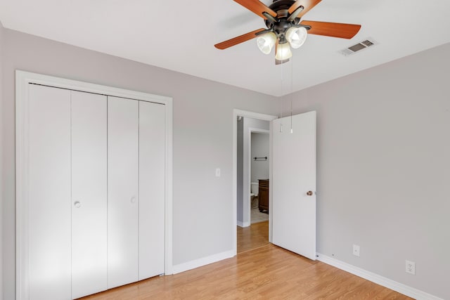 unfurnished bedroom with a closet, light hardwood / wood-style flooring, and ceiling fan