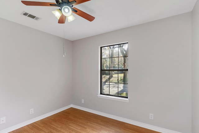 empty room with hardwood / wood-style flooring, plenty of natural light, and ceiling fan