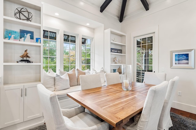 dining room featuring built in shelves, hardwood / wood-style floors, and vaulted ceiling with beams