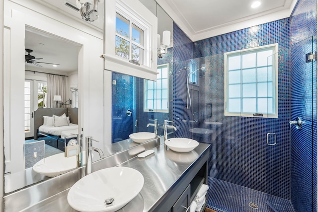 bathroom with ceiling fan, vanity, a shower with shower door, and ornamental molding