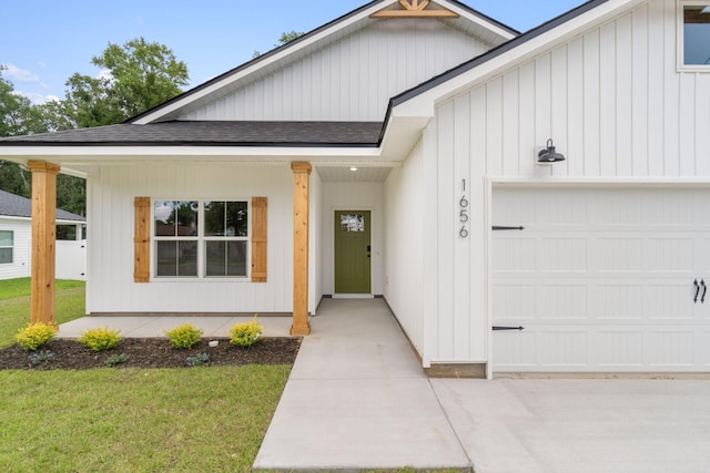 view of front of house featuring a porch, a garage, and a front lawn