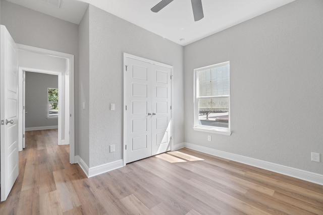 unfurnished bedroom with ceiling fan and light hardwood / wood-style floors