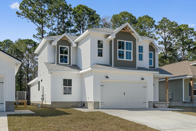 view of front of house with a shingled roof, an attached garage, board and batten siding, driveway, and a front lawn