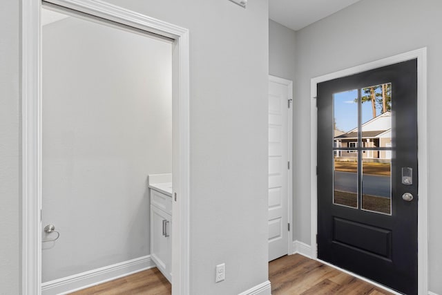 foyer entrance with light wood-type flooring and baseboards