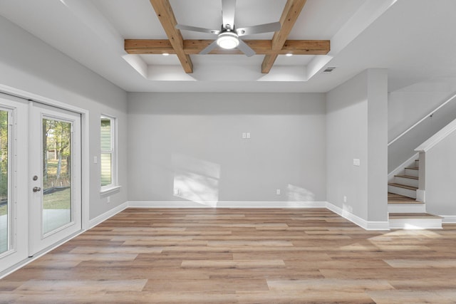 unfurnished room featuring light wood-style floors, coffered ceiling, baseboards, and stairs