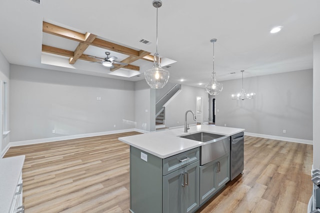 kitchen featuring decorative light fixtures, visible vents, open floor plan, light countertops, and a center island with sink