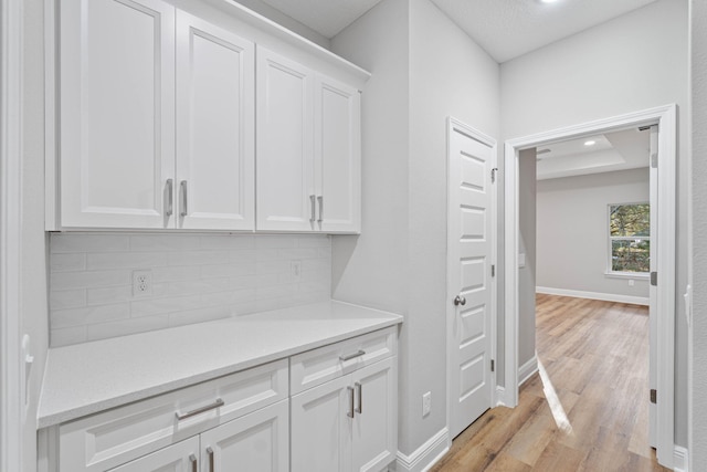 interior space with recessed lighting, backsplash, light wood-style flooring, and baseboards