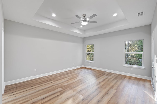 spare room with a raised ceiling and baseboards