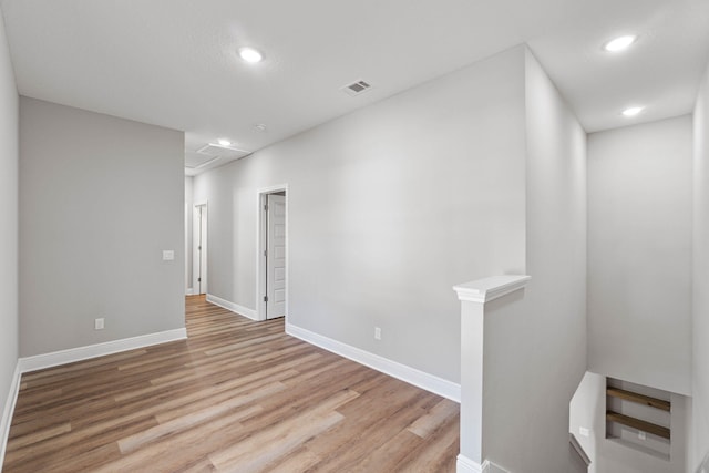 empty room with light wood-type flooring, visible vents, baseboards, and recessed lighting