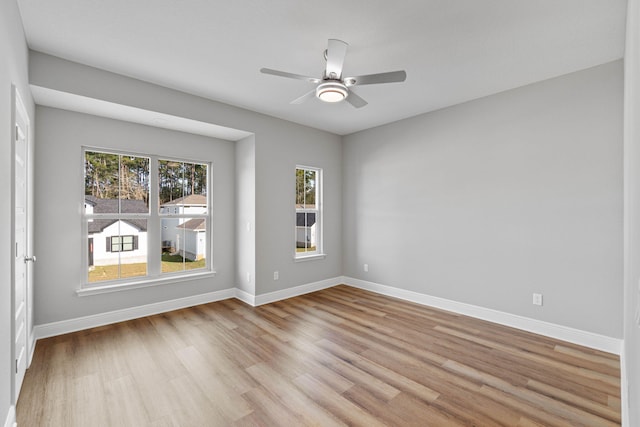 empty room featuring light wood-style floors, baseboards, and a ceiling fan